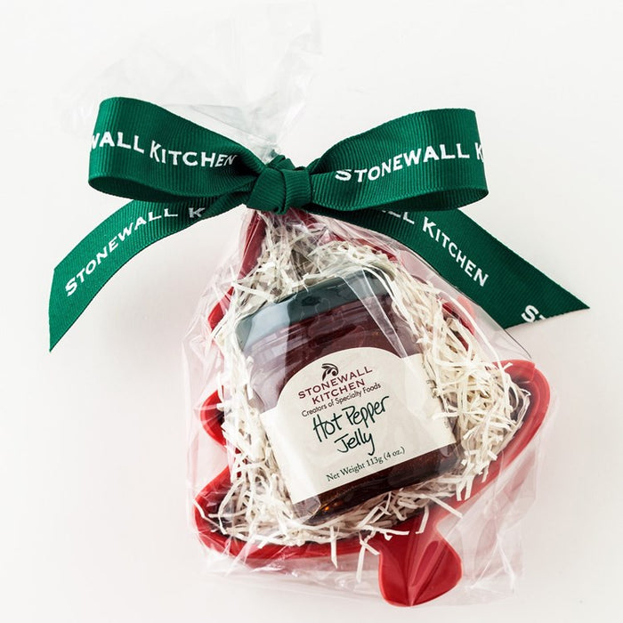 Stonewall Kitchen hot pepper jelly in a clear bag with a green ribbon on a white background
