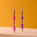 Two pens with colorful accents on a mustard yellow and beige background