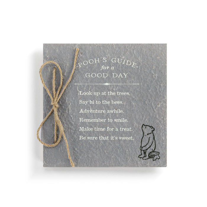 Slate tile with 'Pooh's Guide for a Good Day' text and a small illustration of Pooh Bear on a white background.
