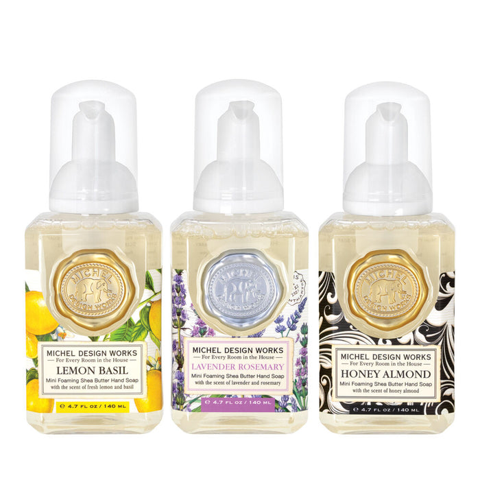 Three bottles of Michel Design Works hand soap with different scents on a white background