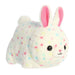 Plush toy rabbit with colorful spots on a white background