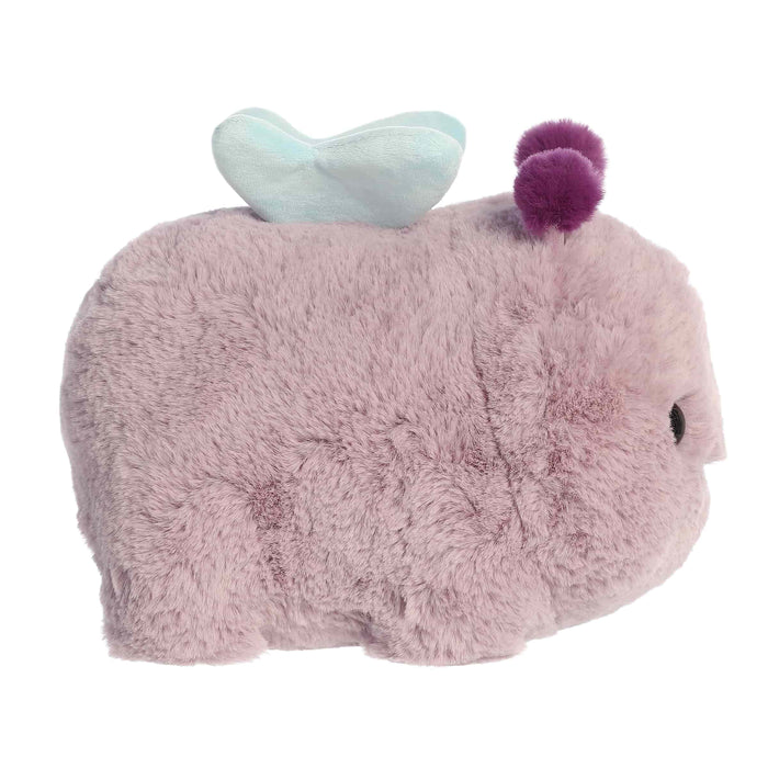 Plush toy resembling a rhino with a heart on its back and a purple pom-pom, on a white background