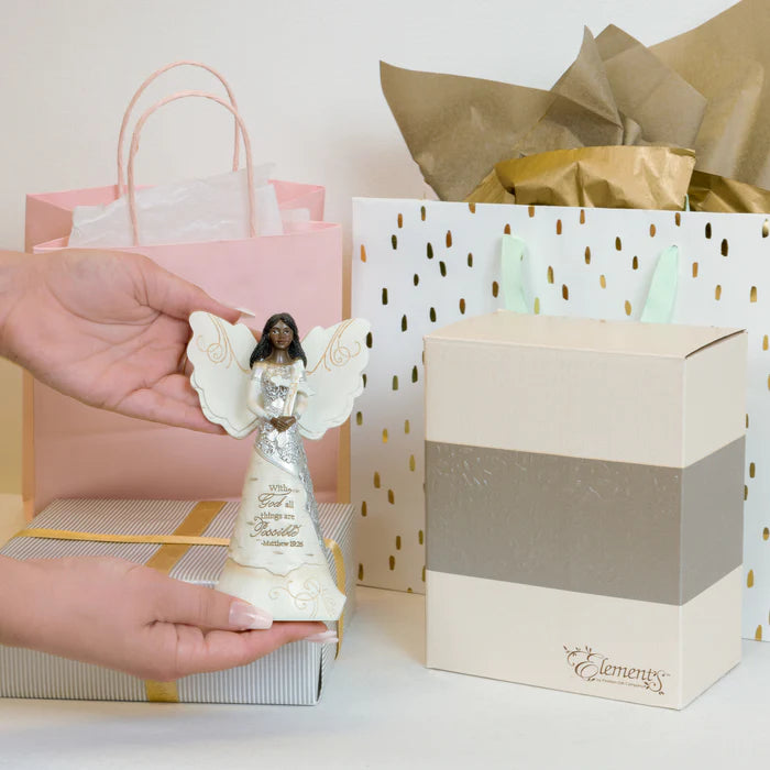 Hand holding an angel figurine with gift bags and boxes in the background