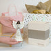Hand holding an angel figurine with gift bags and boxes in the background
