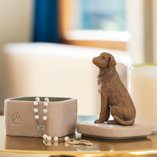Ceramic dog figurine and bowl on a table with a blurred background