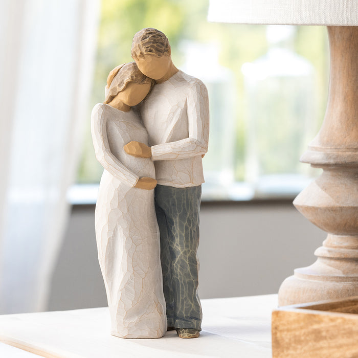 Statue of a couple embracing on a table with a blurred background