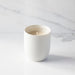 White ceramic mug with gold text on a marble surface