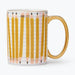 A white ceramic mug featuring a printed pattern of yellow pencils on lined notebook paper, with a shiny gold handle and rim.