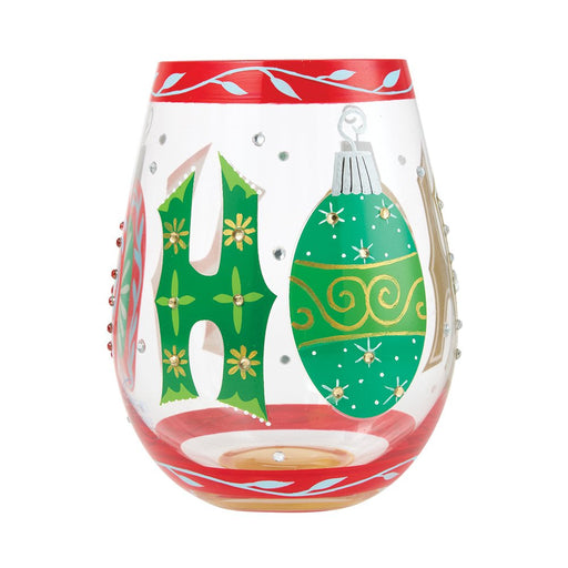 A clear stemless wine glass candle holder decorated with a red top and bottom rim, featuring a green letter 'H' with yellow flowers and a green Christmas ornament motif on the front.