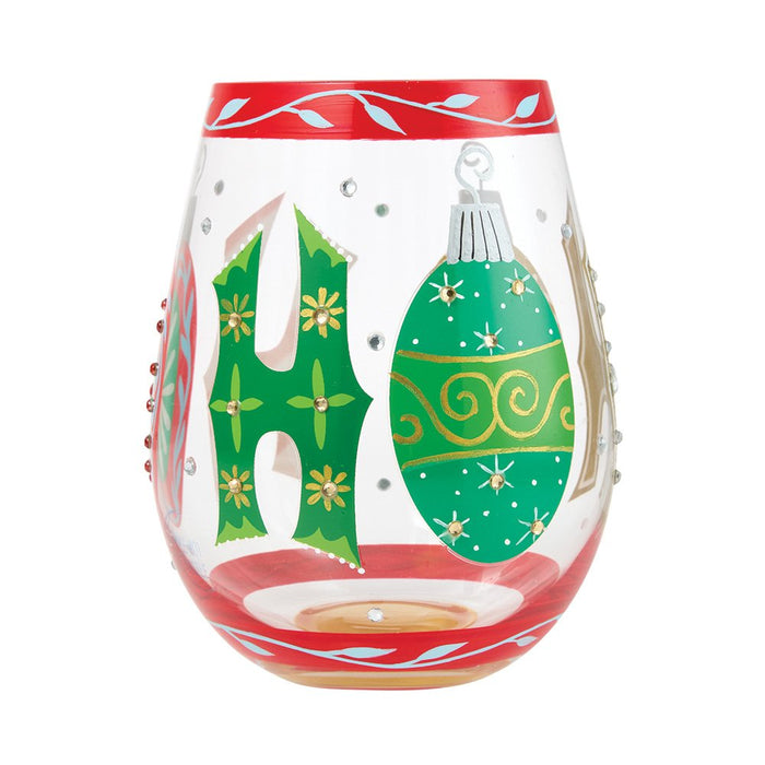 A clear stemless wine glass candle holder decorated with a red top and bottom rim, featuring a green letter 'H' with yellow flowers and a green Christmas ornament motif on the front.