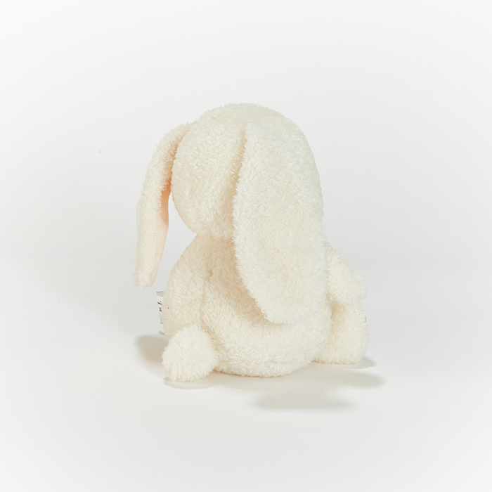 White plush toy resembling a rabbit on a light gray background