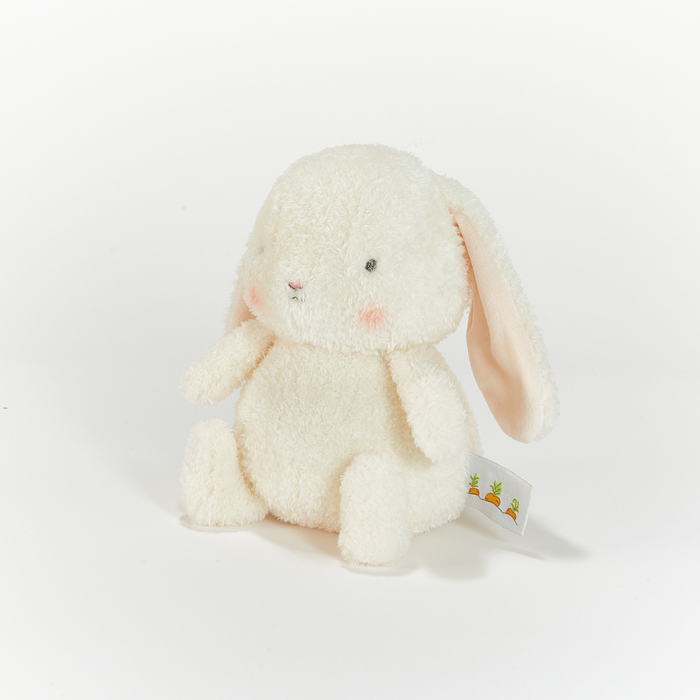 White plush bunny toy with a tag on a light gray background