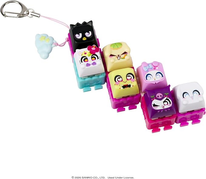 A set of six small character-shaped keychain charms attached to a silver key ring with a pink strap, shown on a plain white background. The charms have colorful faces and are arranged in a staggered row.