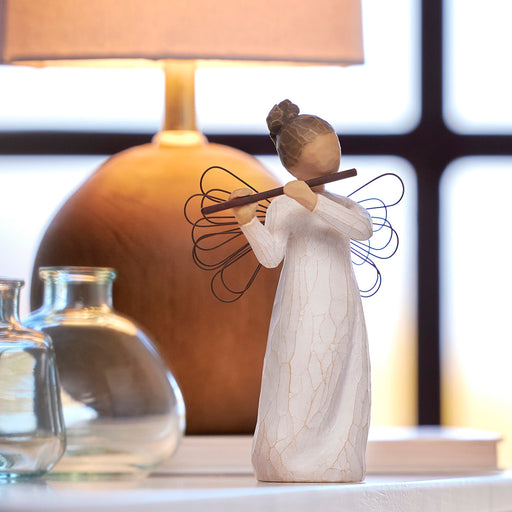 Decorative angel figurine with a blurred lamp and vases in the background