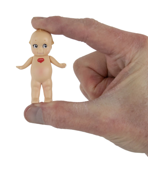 Small figurine of a baby held between fingers against a white background