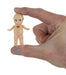 Small figurine of a baby held between fingers against a white background