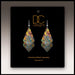 Colorful earrings on a black card with 'DC Designs' branding