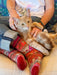 Person wearing colorful patterned socks with a cat on their lap