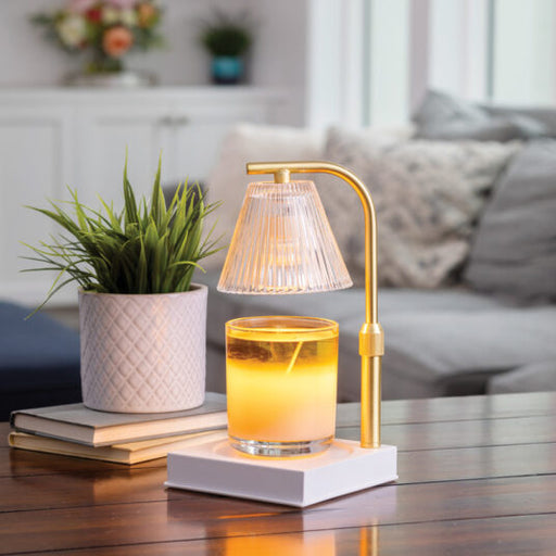Gold table lamp with a glass of water on a wooden surface in a living room setting.