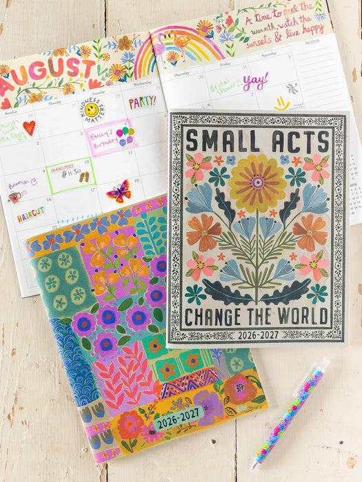 Colorful planner with floral design and text on a wooden surface
