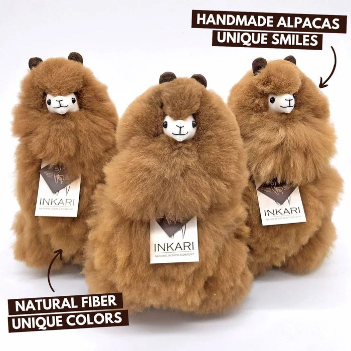 Three plush alpacas with 'INKARI' tags on a white background, labeled as handmade with unique smiles and natural fiber.