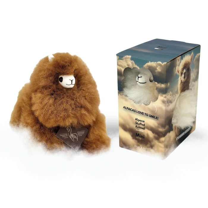 Brown plush alpaca toy next to its packaging on a white background