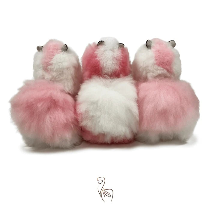 Three fluffy faux-fur sheep or alpaca figures shown from the back in pink and white, arranged side by side on a plain white background.