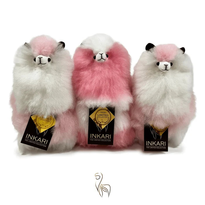 Three plush llamas with pink and white fur, each wearing an Inkari tag, on a white background.