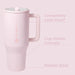 Pink travel mug with handle on a light pink background