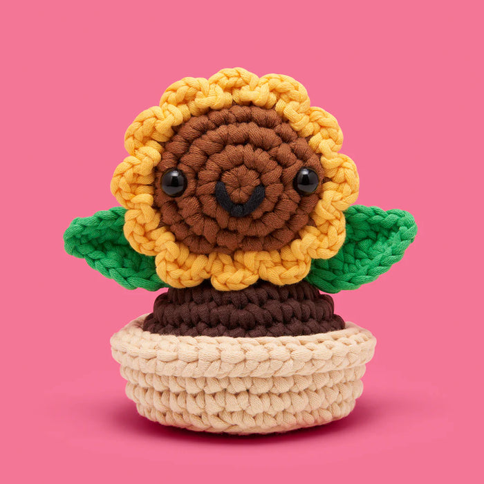 Crocheted sunflower toy with a pink background