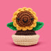 Crocheted sunflower toy with a pink background