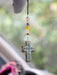 Decorative cross with beads hanging from a car's rearview mirror