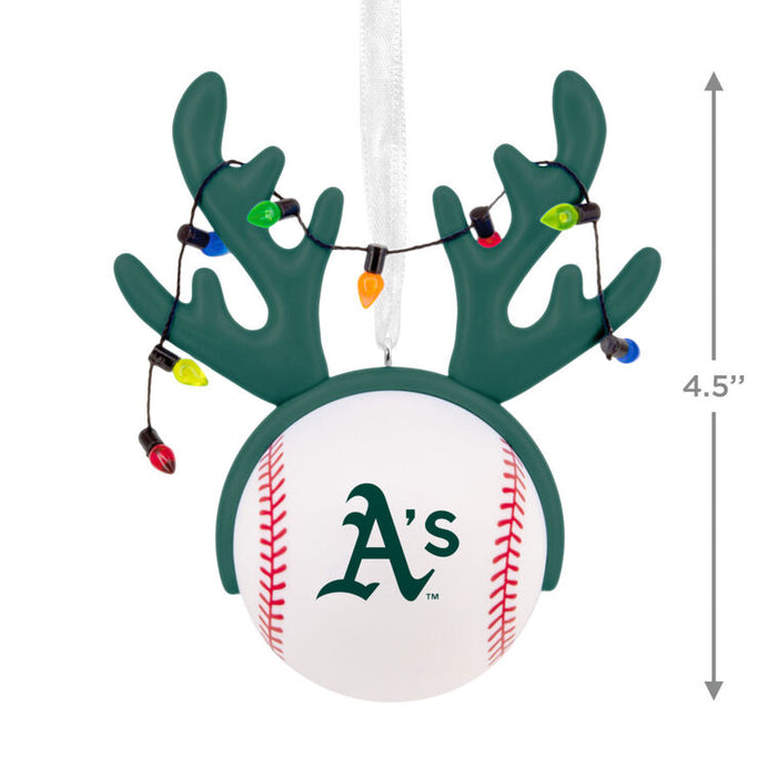 An Oakland Athletics Christmas ornament shaped like a baseball with green antlers and hanging multicolor Christmas lights, shown on a white background with a 4.5-inch height measurement marker.