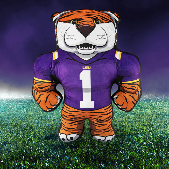 Plush tiger mascot toy wearing a LSU jersey on a grass field with a dark blue sky.