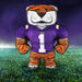 Plush tiger mascot toy wearing a LSU jersey on a grass field with a dark blue sky.