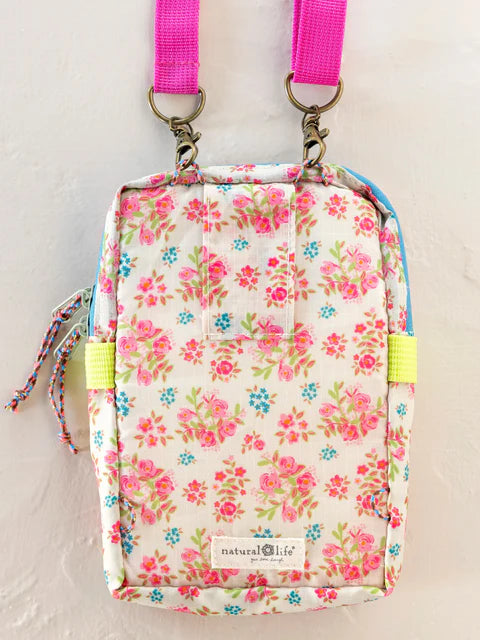 Floral-patterned bag with pink straps on a light background