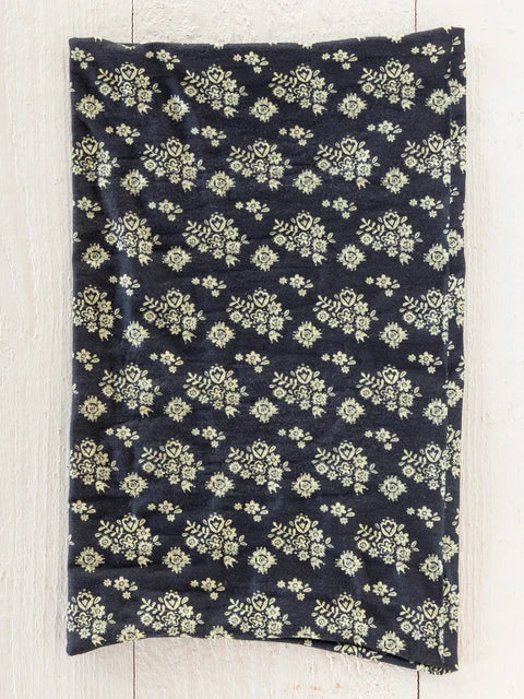 Navy blue fabric with light green floral pattern on a wooden surface
