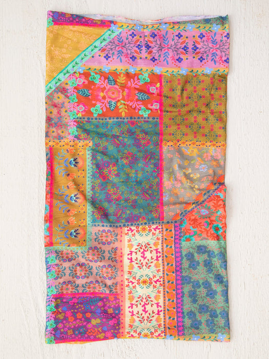 Colorful patchwork quilt with floral patterns on a white background