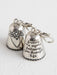 Silver bell charm with floral design and engraved text on a white background