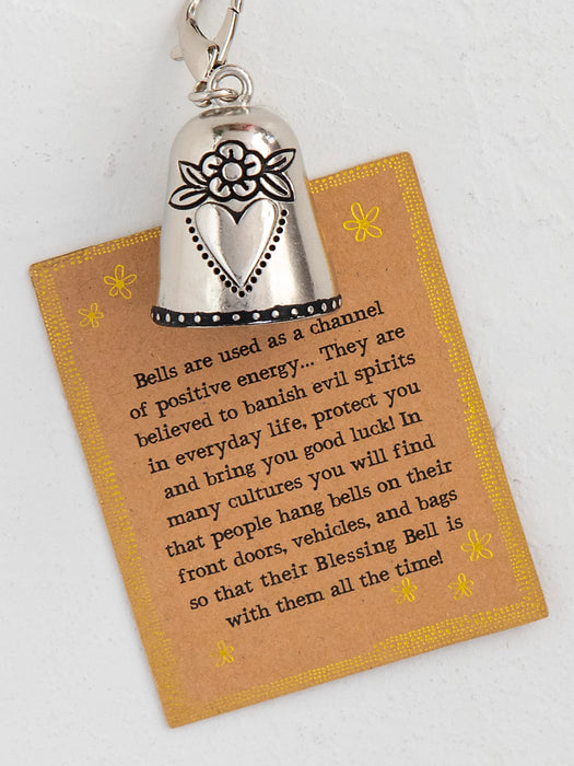 Blessing bell keychain with a card explaining its use on a white background