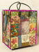 Colorful patchwork tote bag with floral patterns and text on a beige background