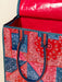 Red and blue patterned bag with paisley design on a beige background