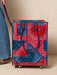 Red and blue patterned rolling shopping bag on a beige background