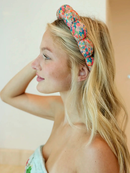 Woman wearing a colorful headband with a neutral background