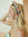 Woman wearing a colorful headband with a neutral background