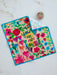 Colorful mat with floral patterns and text 'You are so loved' on a white surface.