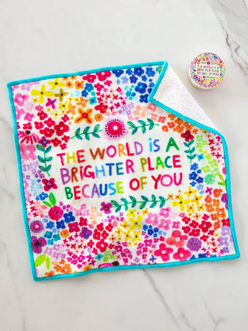 Colorful towel with floral design and motivational quote on a white surface