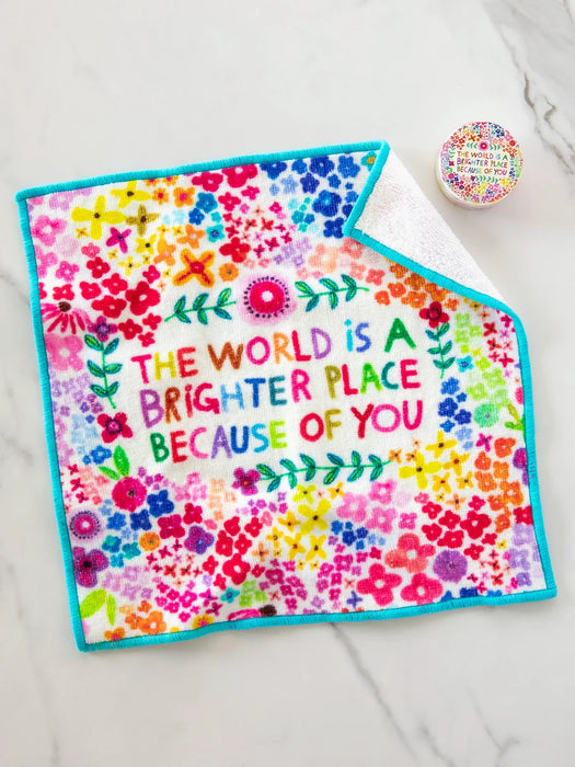 Colorful towel with floral design and motivational quote on a white surface