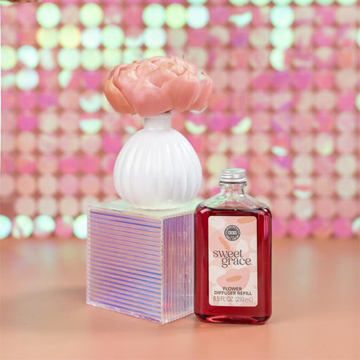 Two perfume bottles with decorative caps on a colorful, sequined background