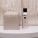 Bottle of cleaning spray and tissue box on a bathroom counter with tiled wall background